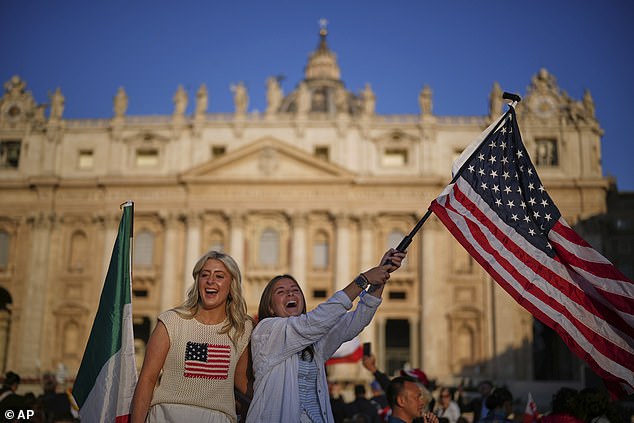 A woman waves a United States flag ahead of Pope Leo XIV's formal inauguration of his pontificate