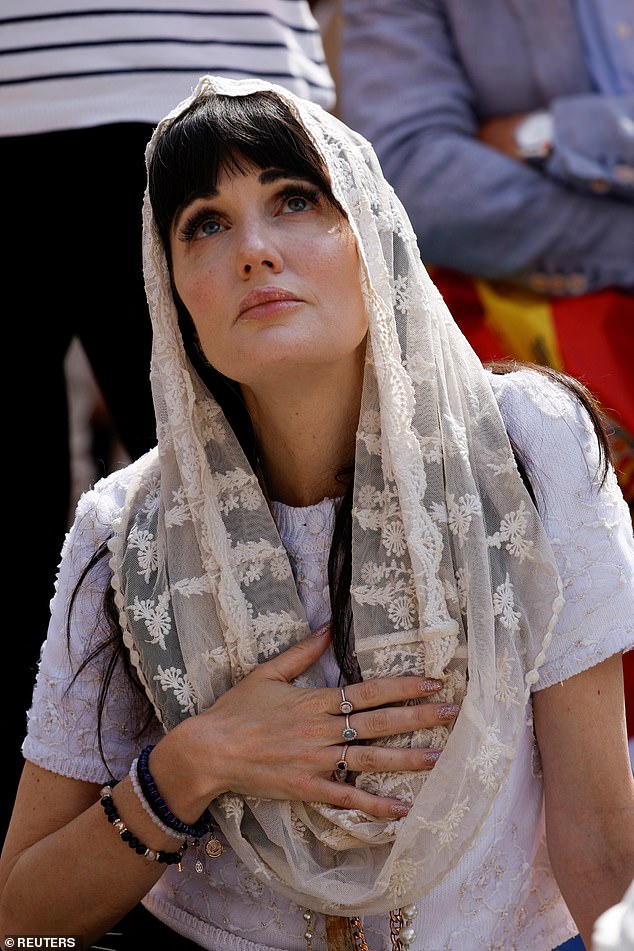 A woman looks up during Pope Leo XIV's inaugural mass at the Vatican