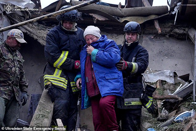 Rescuers were seen escorting a woman from a damaged house following Russian strikes to the Khmelnytsky region