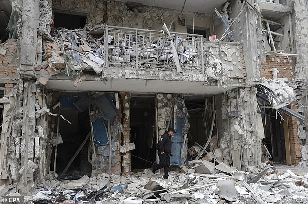 Ukrainian experts work at the site of a residential building struck by a drone as a result of an overnight strike in Kyiv