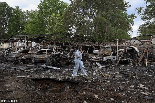 An Odesa resident walks past a crater that appeared after a Russian drone strike in a residential area