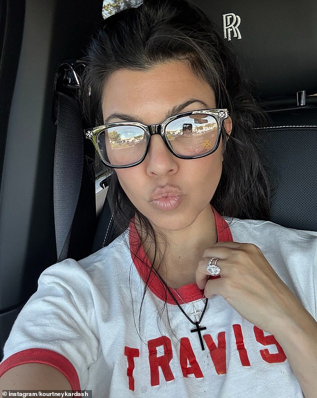 In another shot, Kourtney rocked a 'Travis' T-shirt and flashed her massive diamond wedding ring as she snapped a photo of herself in a Rolls-Royce