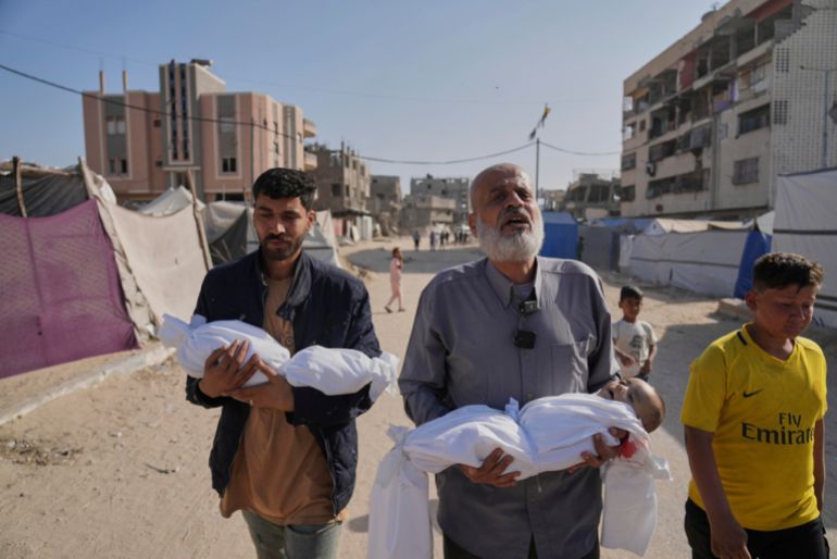 Abdel Rahman Sinwar, left, carries the body of his infant son, Yahia Sinwar, while the child's grandfather carries the body of his one-year-old grandson, Seif Sinwar