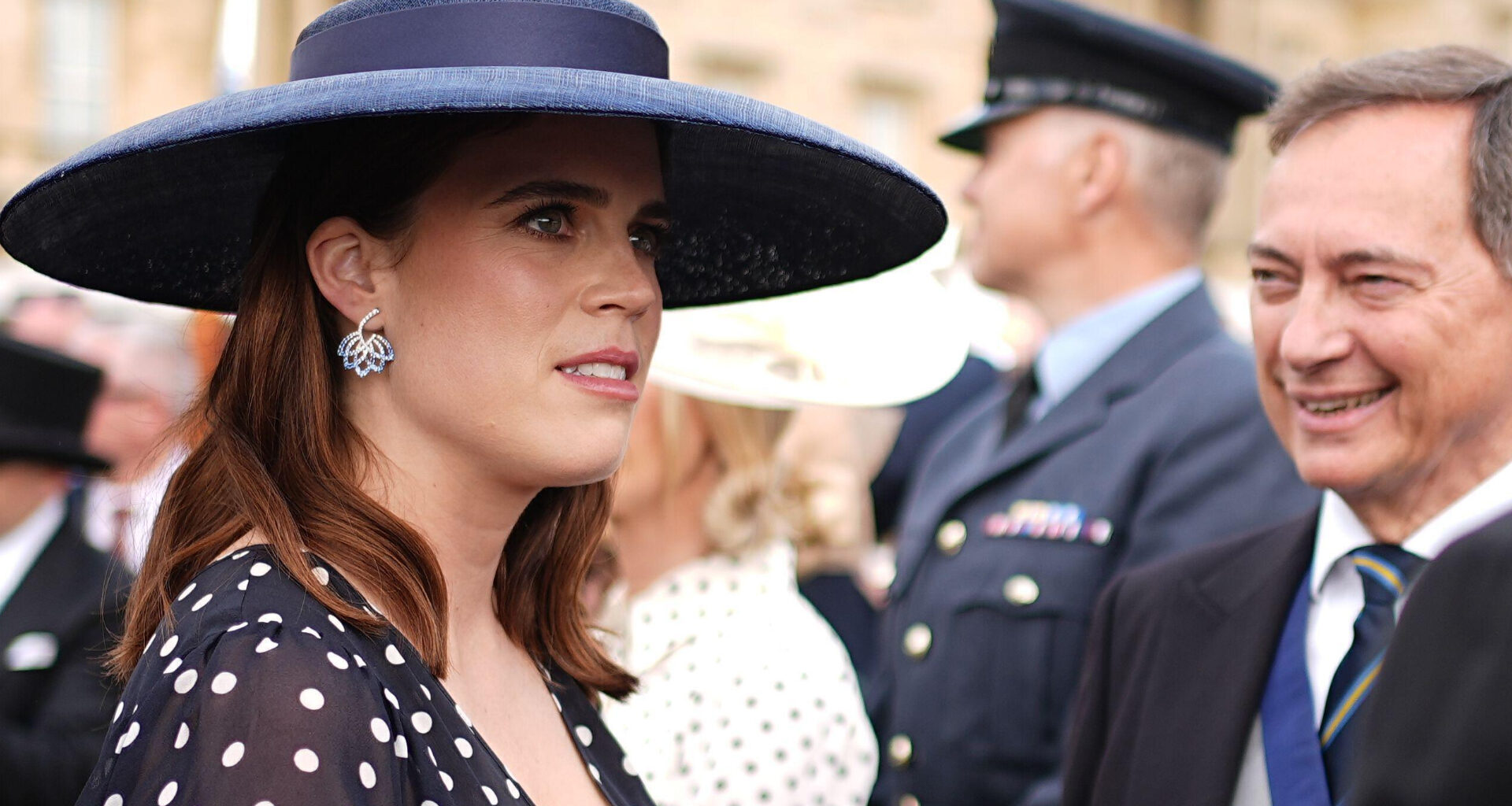 Princess Eugenie wearing a navy dress and hat