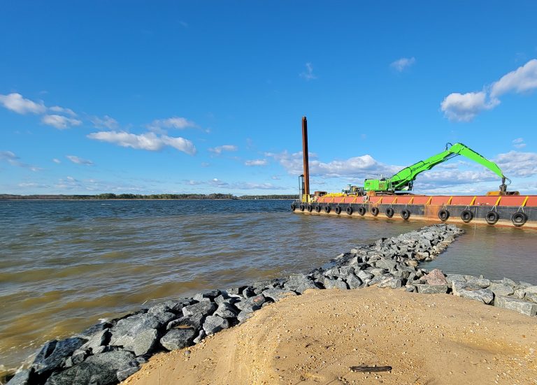 A barge places rocks to help reinforce a shoreline at the North Point of the reserve. CBEC photo