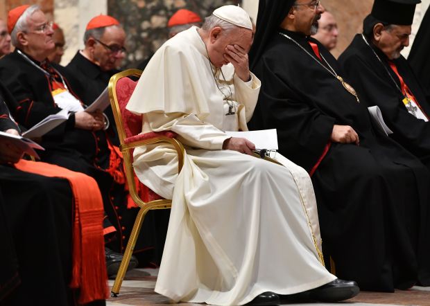 Pope Francis reacts as he takes part in a prayer along with cardinals on the third day of a landmark 2019 Vatican summit on tackling clergy sexual abuse.