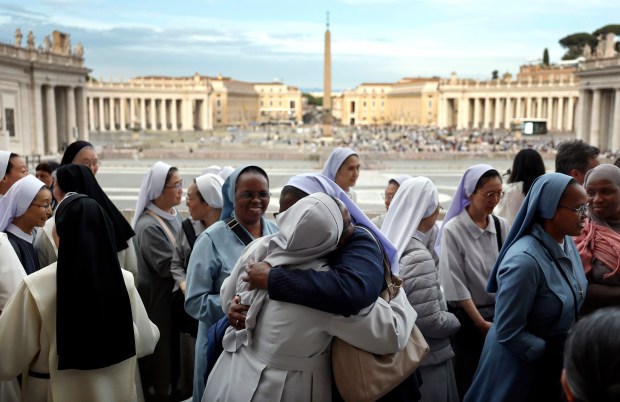 Nuns embrace in St. Peter's Square on Saturday after attending a mass for the late Pope Francis.