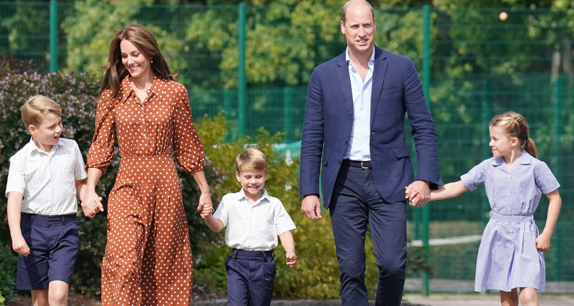 Prince William and Kate Middleton hold hands with their three kids