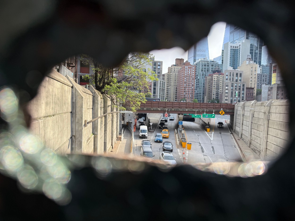 view of dyer ave through a hole in a barrier