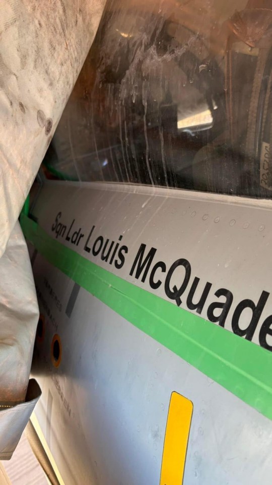 Close-up of a Hawker Hunter jet's fuselage with "Sqn Ldr Louis McQuade" painted on it.