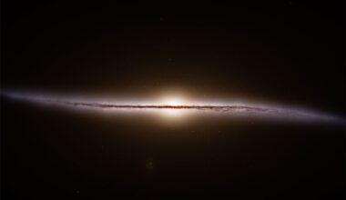 A dark field of space surrounds a thin but
colorful band horizontally across the center. 
The band is nearly straight but curves at its
outer edges. 
Please see the explanation for more detailed information.
