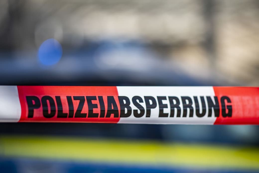 Polizeiabsperrung Ein Absperrband mit der Aufschrift «Polizeiabsperrung» ist vor einem Polizeiwagen aufgespannt. Foto: David Inderlied/dpa