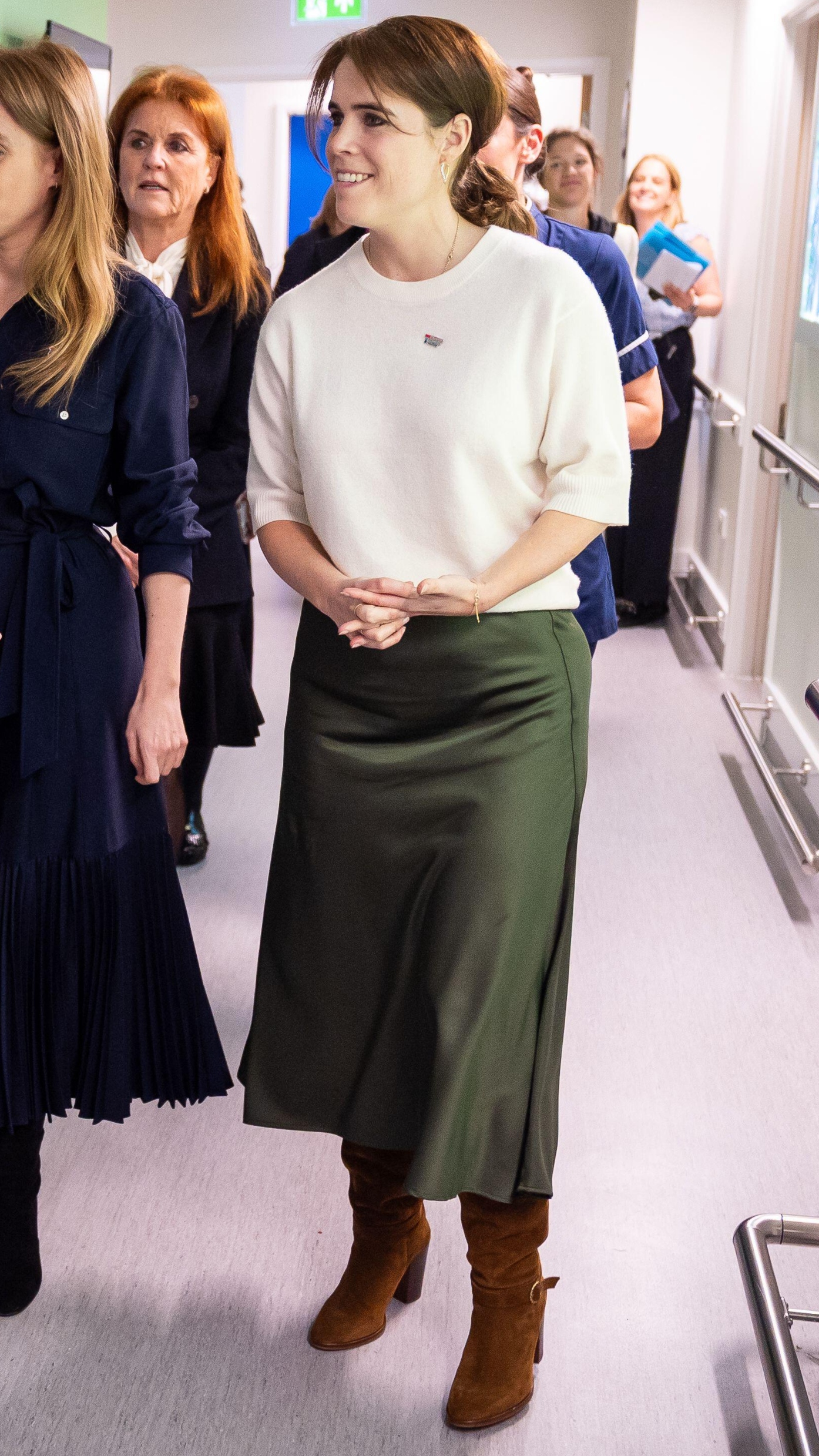 Princess Beatrice and Princess Eugenie speak to a nurse during a visit to the Teenage Cancer Trust unit at University College Hospital