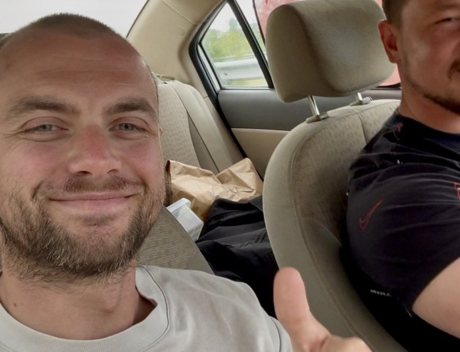 John Dougan with a thumbs up in a car