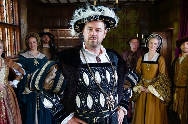 Danny Dyer dressed as a Tudor courtier in the era of his 15 x grandfather Sir John Seymour surrounded by others in period clothing