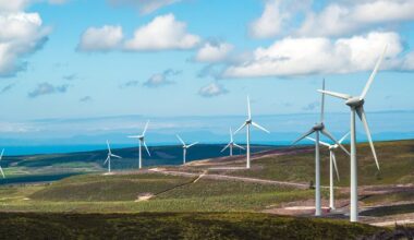Wind turbines on brown hills under a blue sky