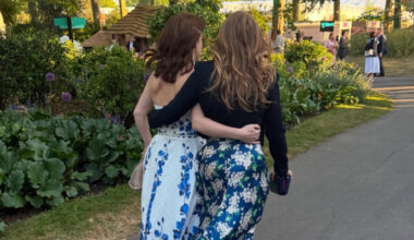 Princess Beatrice and Princess Eugenie walking with their arms around each other at the Chelsea Flower Show