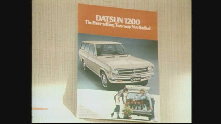 A poster showing the orange Datsun.