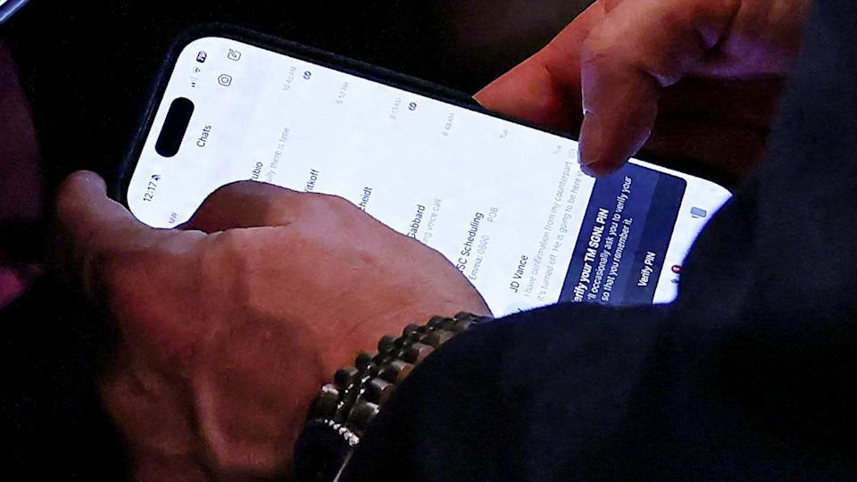 National Security Advisor Mike Waltz checks his mobile phone while attending a Cabinet meeting held by President Donald Trump at the White House in Washington, D.C., on April 30. (Evelyn Hockstein/Reuters)