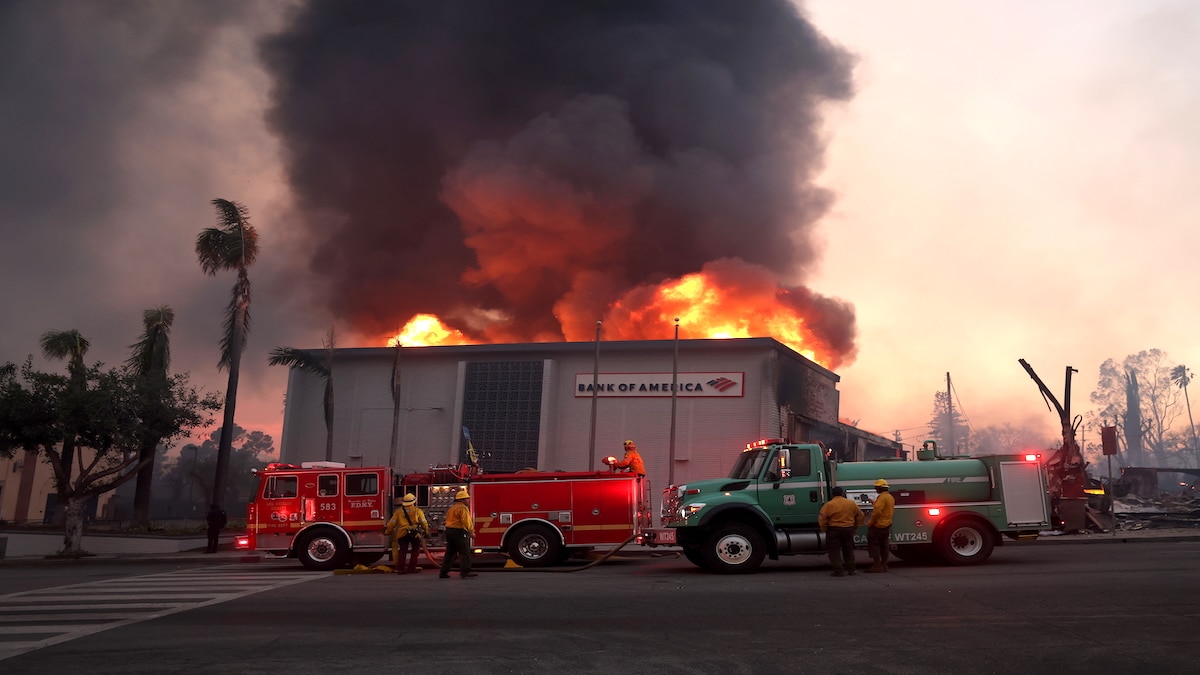Los Angeles County firefighters attempt to put out a fire at a Bank of America as the Eaton Fire, which destroyed many homes and businesses, moves through Altadena, California