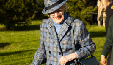 Queen Margrethe wearing a blue plaid coat and matching hat smiling