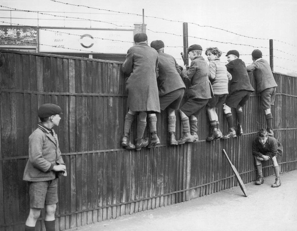 Circa 1945, Schoolboys clamber up a fence at Oval in London, to watch the cricket. (Photo by FPG/Getty Images)
