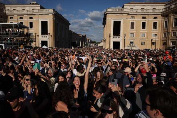 Crowds gathered around St. Peter's Square react on May 8,...
