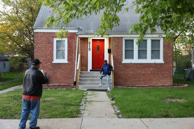 Rosetta Polk has her picture taken in front of the childhood home of new Pope Leo XIV, May 8, 2025, in Dolton. (John J. Kim/Chicago Tribune)