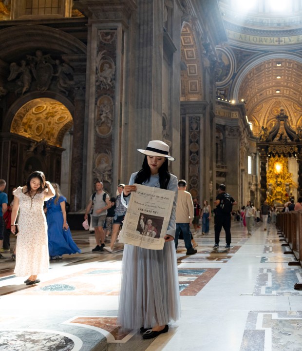 A woman holds a picture of Pope Leo XIV while visiting St. Peter's Basilica on May 15, 2025, before the installation at the Vatican. (Brian Cassella/Chicago Tribune)