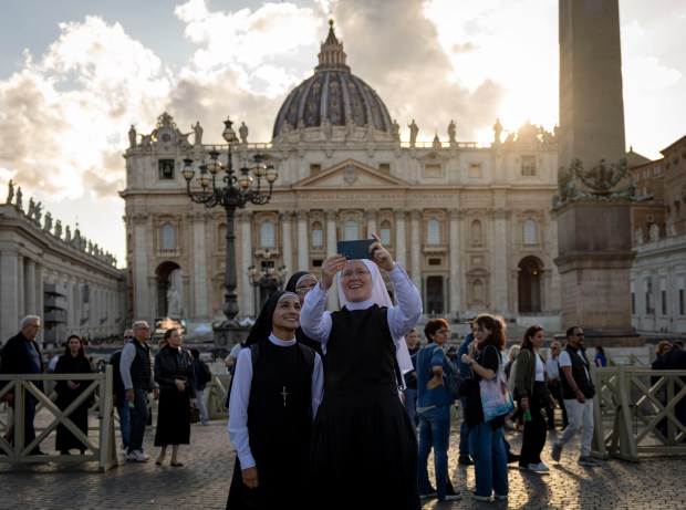 Nuns take pictures in St. Peter's Square on May 16, 2025, before the installation of Pope Leo XIV at the Vatican. (Brian Cassella/Chicago Tribune)