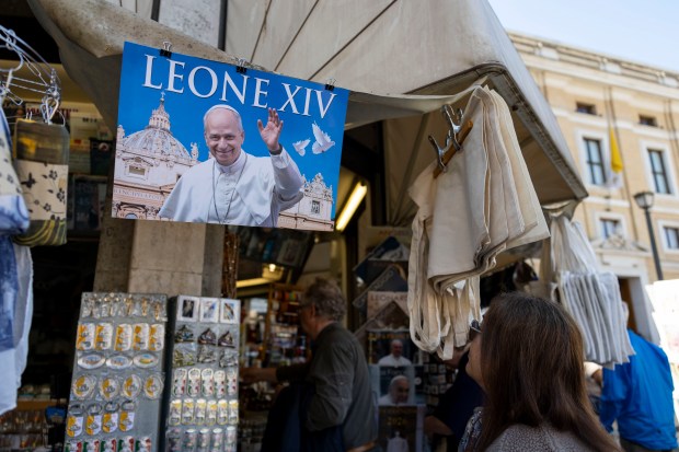 A photo of Pope Leo XIV is displayed on a souvenir stand next to St. Peter’s Square on May 17, 2025, a day before his installation at the Vatican. (Brian Cassella/Chicago Tribune)