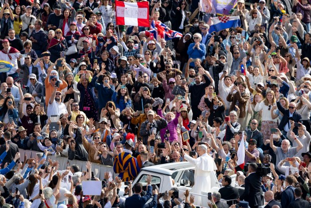 Pope Leo XIV waves to the crowds as he arrives...