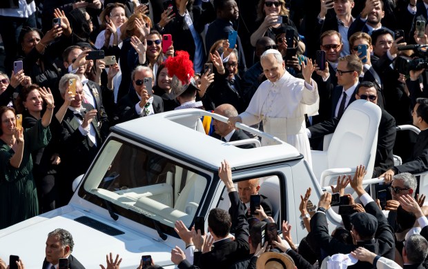Pope Leo XIV waves to the crowds as he arrives...