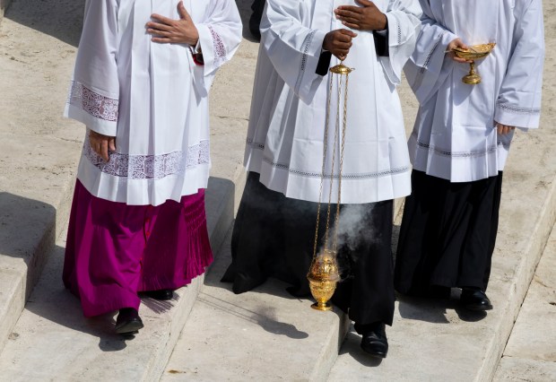 Members of the clergy carry incense as Pope Leo XIV...