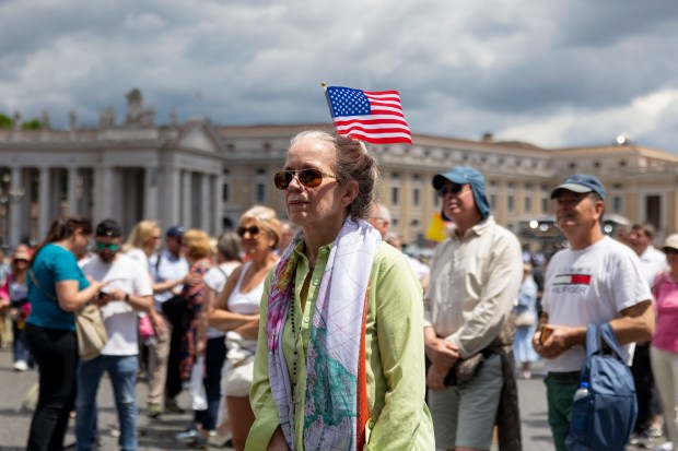 A woman with an American flag watches the screens after...