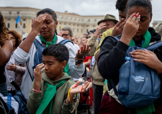 People pray while Pope Leo XIV holds his first general audience in St. Peter's Square at the Vatican on May 21, 2025. (Brian Cassella/Chicago Tribune)