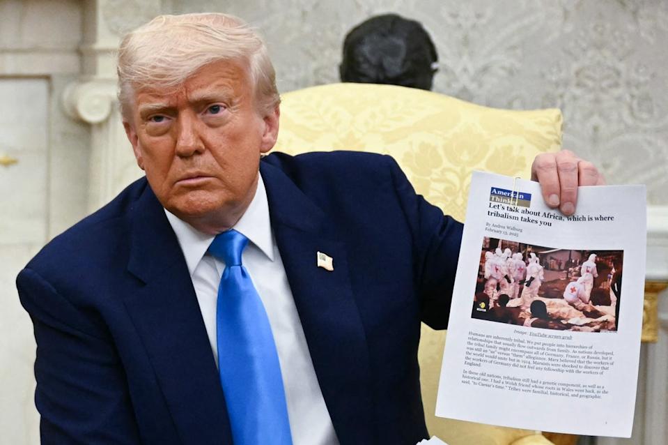 Donald Trump shows pictures as he meets South African president Cyril Ramaphosa at the White House (AFP/Getty)