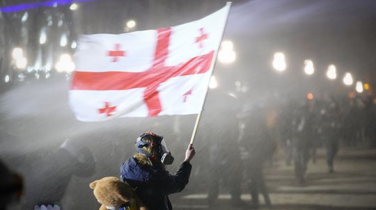 Demonštrant s gruzínskou zástavou počas...