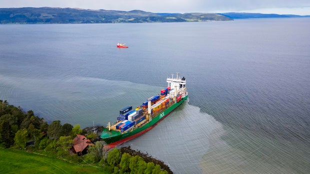 An aerial view shows a 443-foot-long container ship by the shore in the Trondheimsfjord outside Byneset by Trondheim, Norway, on May 22, 2025, after it ran aground, almost hitting a house. 