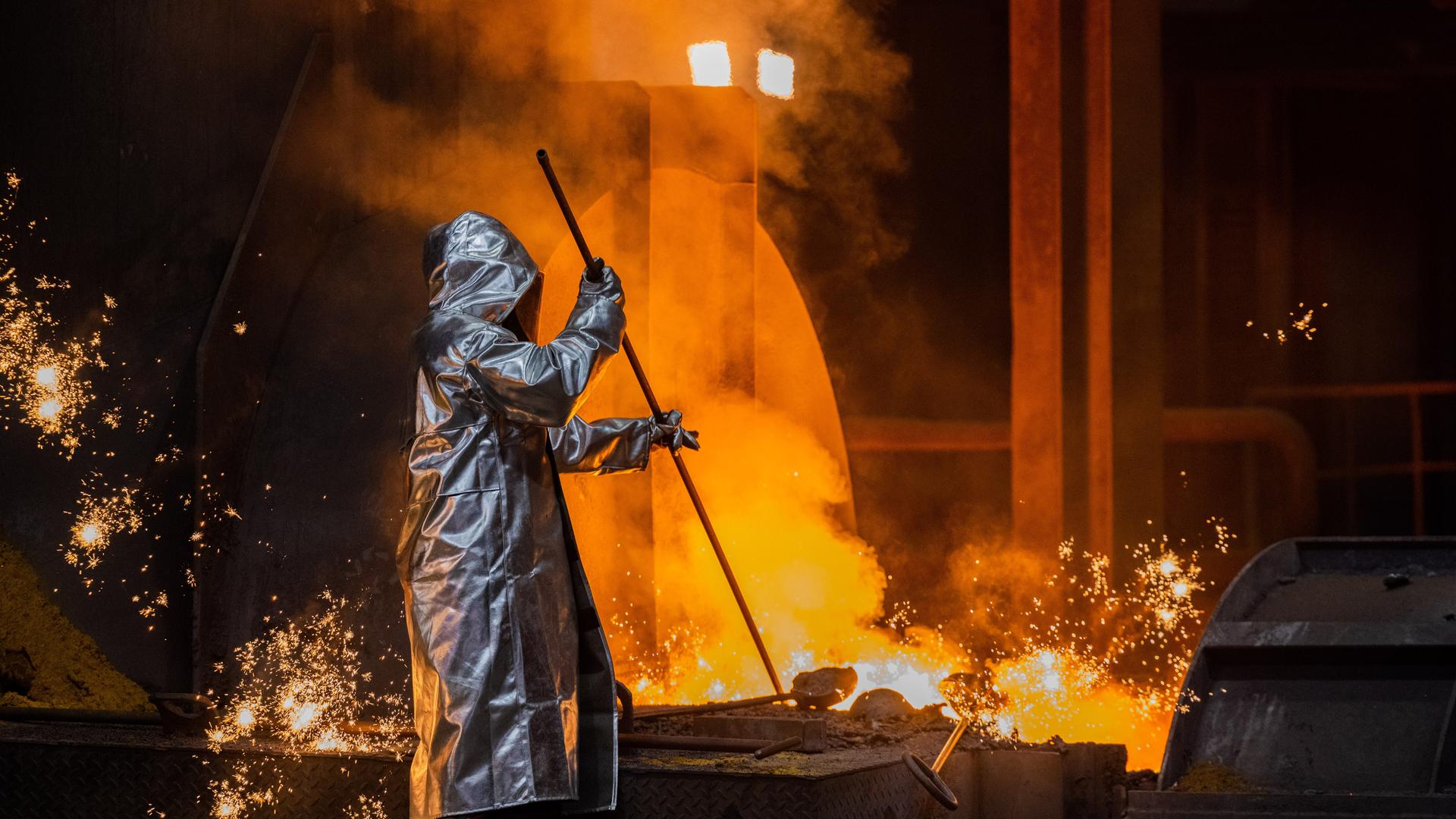 Ein Stahlarbeiter von Thyssenkrupp prüft den Roheisen am Hochofen 8 auf dem Werksgelände. Ein Stahlarbeiter von Thyssenkrupp prüft den Roheisen am Hochofen 8 auf dem Werksgelände.