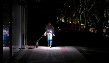 A woman in Vigo, northwest Spain, uses a torch to navigate the streets during the April 28 Iberian power outage