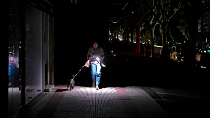 A woman in Vigo, northwest Spain, uses a torch to navigate the streets during the April 28 Iberian power outage