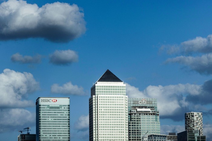 Skyscrapers with HSBC, Citi and pyramid-roofed towers under a blue sky with scattered clouds