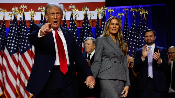 US President Donald Trump points to supporters with first lady Melania Trump during an election night event