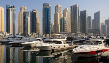 Residential skyscraper buildings beyond motor yachts docked in the Dubai marina district of Dubai, United Arab Emirates
