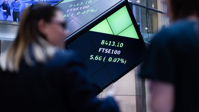 Stock price information for the FTSE 100 index displayed on a board at the London Stock Exchange