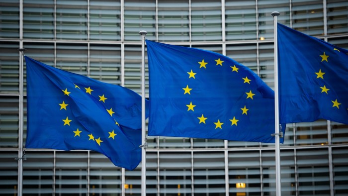 Flags of the EU wave in the wind in front of the Berlaymont building of the European Commission in Brussels