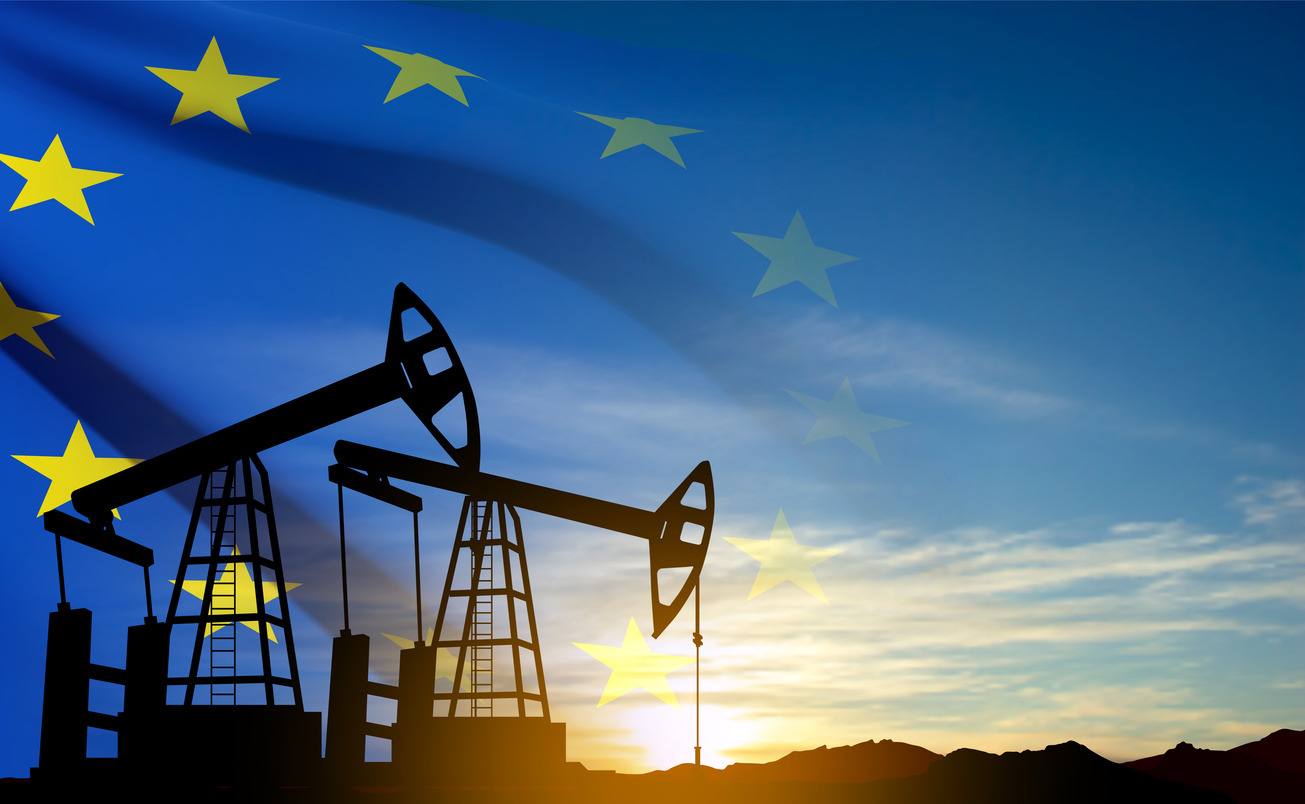 Oil rigs silhouette against sunset ana European union flag