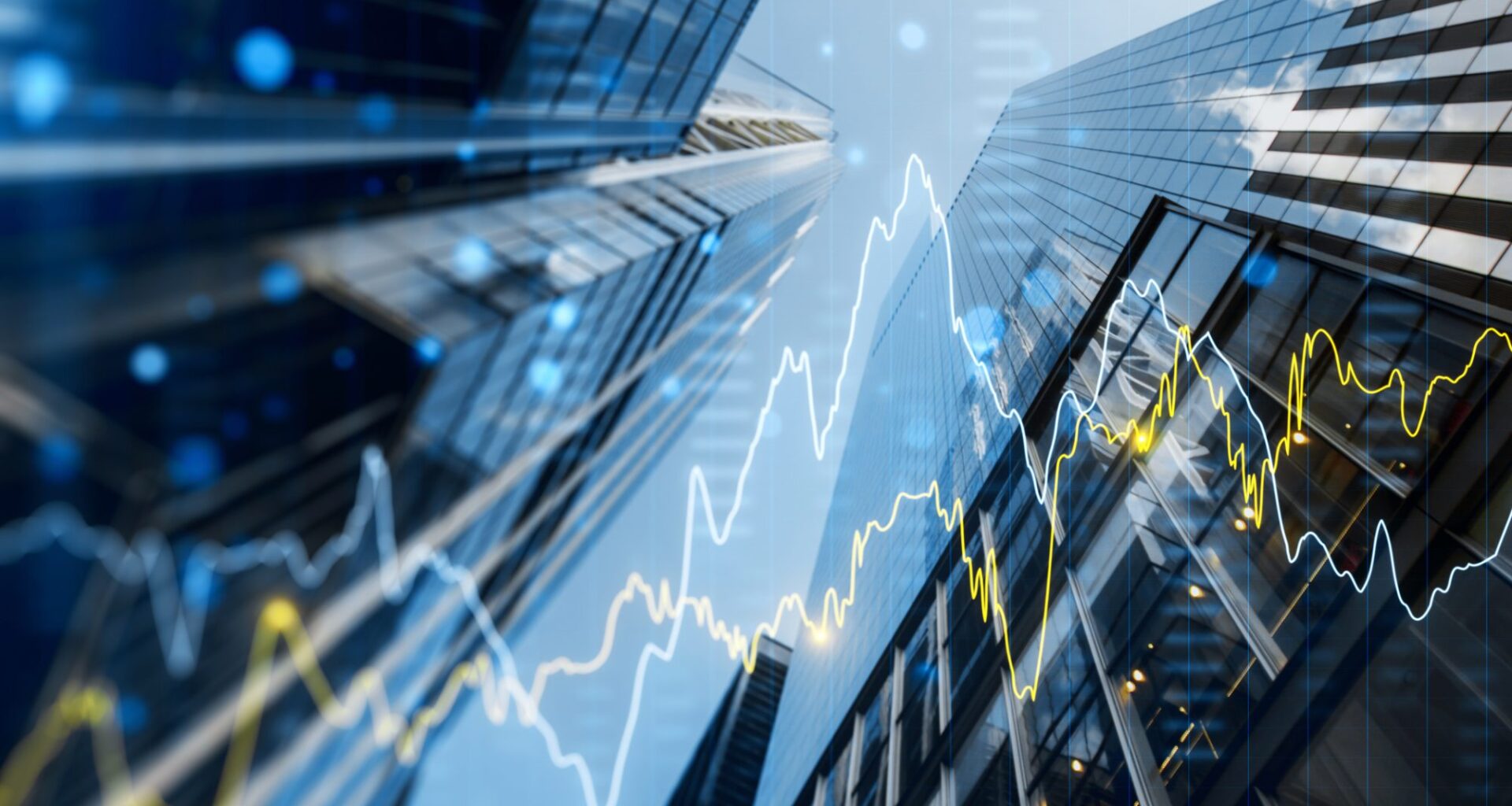 A double exposure image of skyscrapers with overlay of financial graphs, set against a blurred background, illustrating the concept of business growth