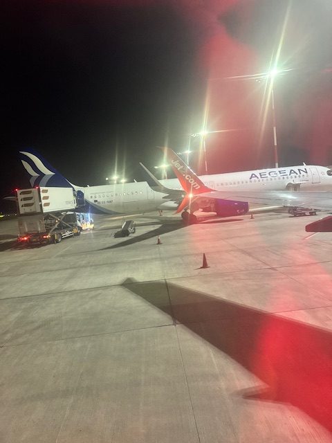 Two airplanes at night on a tarmac.